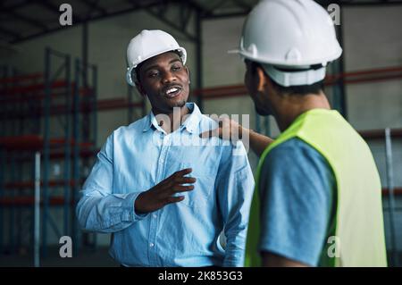 Trust builds relationships, relationships build your brand. two having a conversation in a warehouse. Stock Photo