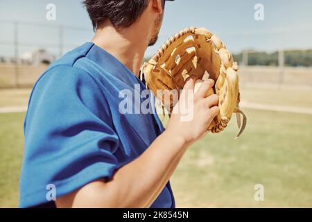 Baseball, sports and man pitching during a game, training and professional event on a field. Back of athlete ready to throw a ball with a glove during Stock Photo