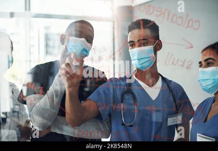 The student has become the master. Shot a group of doctors discussing formulas in the office at work. Stock Photo