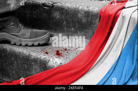 The leg of the military stands on the step next to the flag of Luxembourg, the concept of military conflict Stock Photo