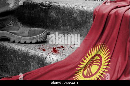 The leg of the military stands on the step next to the flag of Kyrgyzstan, the concept of military conflict Stock Photo