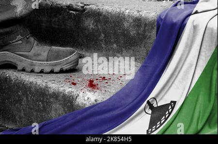 The leg of the military stands on the step next to the flag of Lesotho, the concept of military conflict Stock Photo