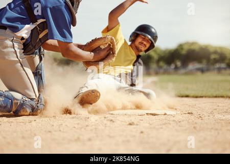 Baseball player, run and slide in dirt for game, contest or match on field, pitch or stadium. Man, baseball and dust in sand for sports to reach base Stock Photo