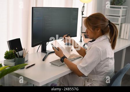 Side view of professional software developer working with coded data in bright modern office Stock Photo