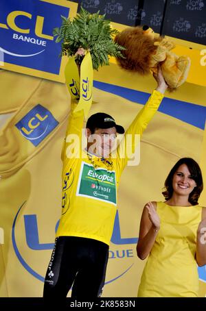 Team Europcar's Thomas Voeckler celebrates on the podium with the yellow leader's jersey  Stock Photo