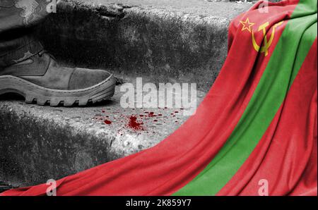 The leg of the military stands on the step next to the flag of Transnistria, the concept of military conflict Stock Photo