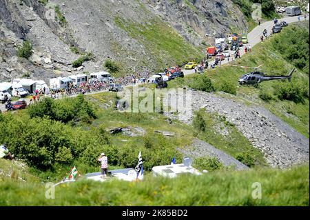 Col de la Madeleine looking down on the peloton and breakaway bunch as they do the first climb of the day with helicopters and fans surrounding them, Stock Photo