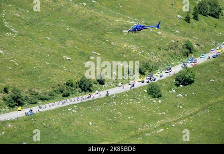 Col de la Madeleine looking down on the peloton and breakaway bunch as they do the first climb of the day with helicopters and fans surrounding them, Stock Photo