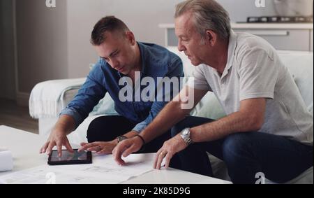 I always need your help with business. a father and son duo going over blueprints at home. Stock Photo