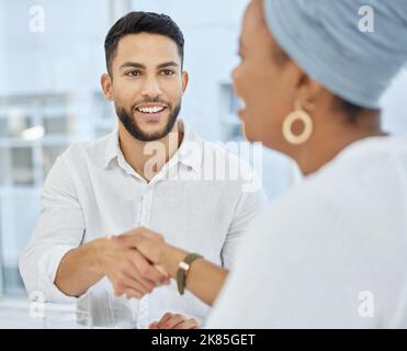 And a handshake seals the deal. two young diverse businesspeople shaking hands during a meeting in the boardroom. Stock Photo