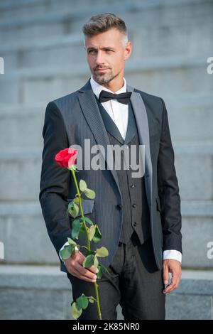 special occasion concept. mature man with rose for special occasion. tuxedo man at special occasion. Stock Photo