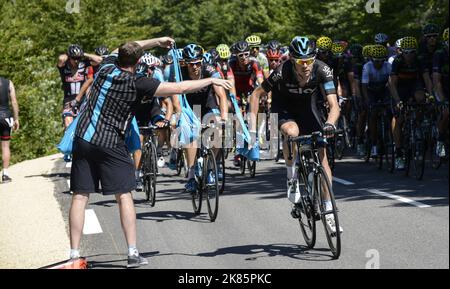A soigneur hands out energy gels and water bottles on the way up the first climb from Bourg de Peage and Gap as Luke Rowe takes one. Stock Photo
