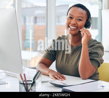 Thank you for reaching out to us. a woman wearing a headset while working in a call centre. Stock Photo