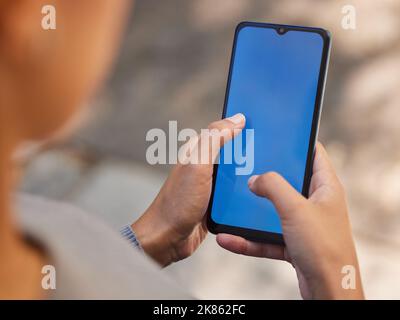 Phone, woman and green screen mock up for brand advertising, marketing app or mobile product website networking. Close up of girl holding smartphone Stock Photo