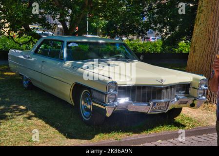 BADEN BADEN, GERMANY - JULY 2022: beige ivory white Cadillac de Ville Third 3rd generation 1965 sedan, oldtimer meeting in Kurpark. Stock Photo