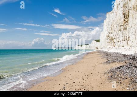 Beach with chalk cliffs and turquoise sea on coast in England Seven Sisters Stock Photo