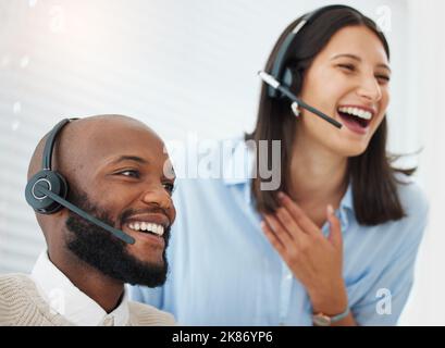 Funny coworkers are the best. a handsome young salesman sitting in the office and wearing a headset while getting help from his manager. Stock Photo