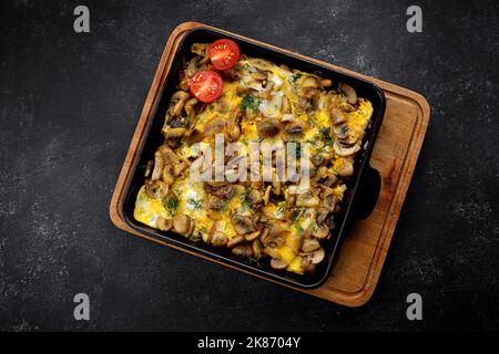 Omelet with mushrooms, onions and dill, in a frying pan Stock Photo