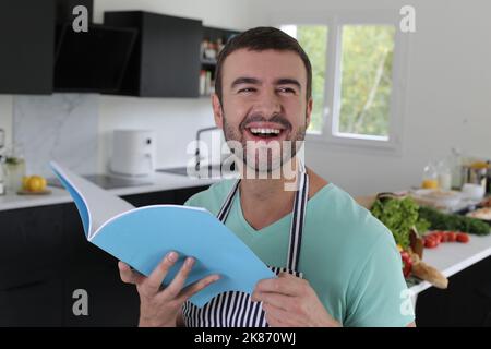Man reading some notes before making some food in the kitchen Stock Photo
