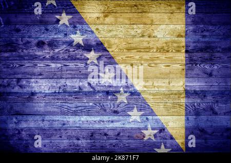 A vignetted background image of the flag of Bosnia and Herzegovina painted onto wooden boards of a wall or floor. Stock Photo