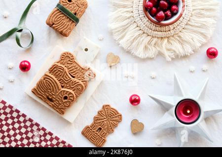 Speculoos or Spekulatius, Christmas biscuits, chocolate balls and ribbon on off white textile tablecloth. Traditional German cookies for Xmas, Advent Stock Photo