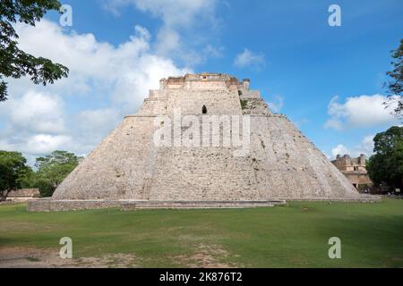 View of the Maya archeological site of Uxmal in Yucatan, Mexico. Mayan ruins with Pyramid Of The Magician and ancient building for tourism and travel Stock Photo