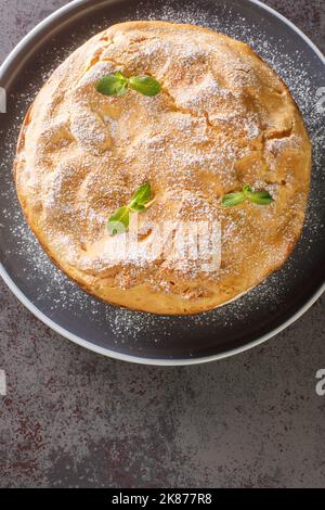 Traditional Polish cake Karpatka of choux pastry dough and custard cream closeup on the plate on the table. Vertical top view from above Stock Photo