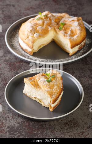 Traditional Polish cake Karpatka of choux pastry dough and custard cream closeup on the plate on the table. Vertical Stock Photo