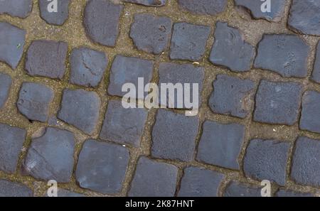 Texture of cobblestone street. Pattern of old avenue. Straight rows of stones. Stock Photo