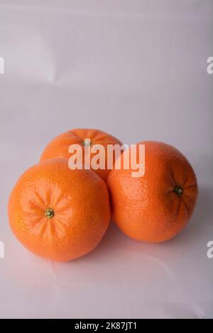 three tangerines lying on a white background Stock Photo