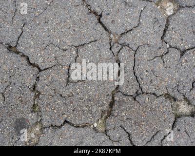 Old cracked grey asphalt surface. Cracked  asphalt texture for background. Front view with copy space. Stock Photo