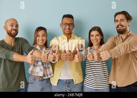 Portrait of smiling young people show thumbs up Stock Photo