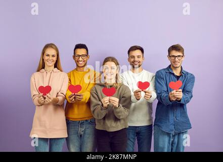 Multiracial group of happy young people holding red Valentine hearts and smiling Stock Photo