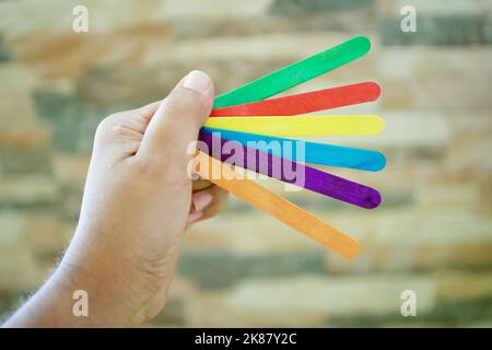 A man holding multi-colored counting sticks for children on a blurred background Stock Photo