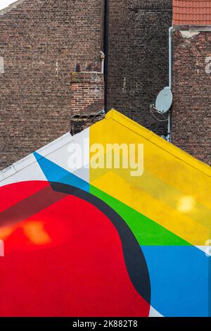 Brightly painted building gable. Dark brick walls in the background. Brussels. Stock Photo