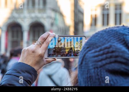 Tourist photographing the Maison du Roi on the Grand Place in Brussels with his smartphone. Stock Photo