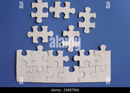 Top view image of incomplete jigsaw puzzle on blue background. Stock Photo