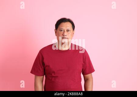 The 40s adult overweight Asian man standing on the pink background. Stock Photo
