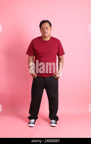 The 40s adult overweight Asian man standing on the pink background. Stock Photo