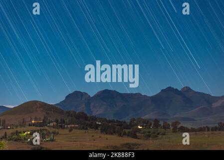 Star trails above the mountains in the town of Clarens, South Africa. This popular tourist destination is near the Golden Gate Highlands National Park Stock Photo