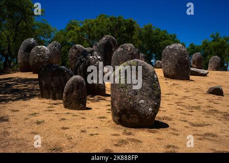 Massive egg-shaped granite boulders, arranged by prehistoric hands up to 7,000 years ago, form the standing stone circles of one of Europe’s oldest and largest megalithic complexes, the Early Neolithic Almendres Cromlech near Évora in Alentejo, southern Portugal.  The megaliths or menhirs were placed in concentric circles to align with the sun, moon and stars. Stock Photo