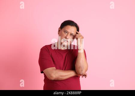 The 40s adult overweight Asian man standing on the pink background. Stock Photo