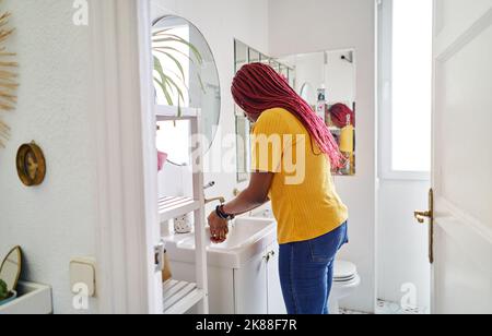 young african american woman washing hands in bathroom at home Stock Photo