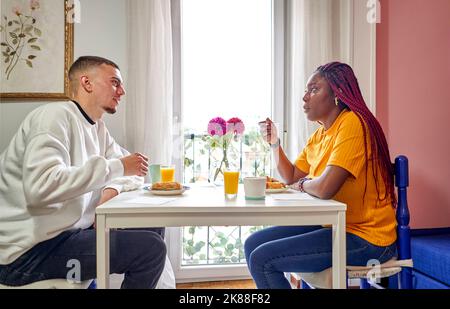 couple having breakfast sitting at table at home Stock Photo