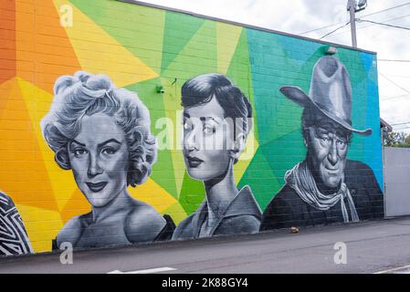 A murual of celebrities appears on the side of a wall of a building in