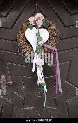 Wedding wreath with heart and ribbon, flower on an old wooden door Stock Photo
