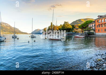 Boats are docked and moored at the peaceful fishing village of Pescallo near the town of Bellagio on Lake Como in Northern Italy at sunset. Stock Photo