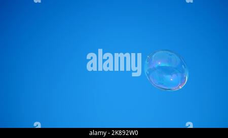 close-up. a big soap bubble flies against the blue sky. High quality photo Stock Photo