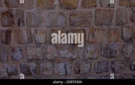 A view of an old stone wall.  Close-up stone wall background. Stock Photo