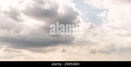 Gray gloomy clouds with occasional gaps in the rays of the sun Stock Photo